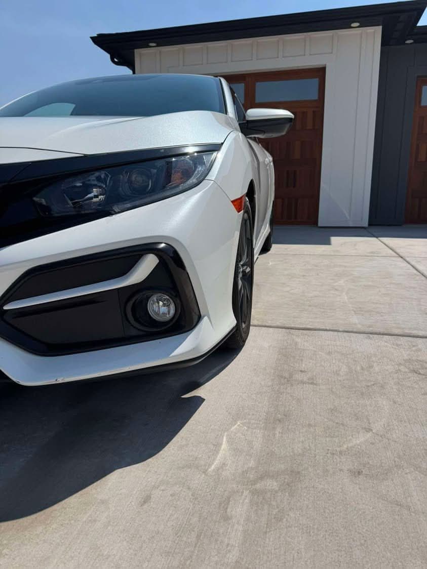 Front of a white Honda Civic with polished paint and clean headlight
